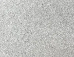 Close-up of a light gray granular surface, like sand or fine gravel texture.