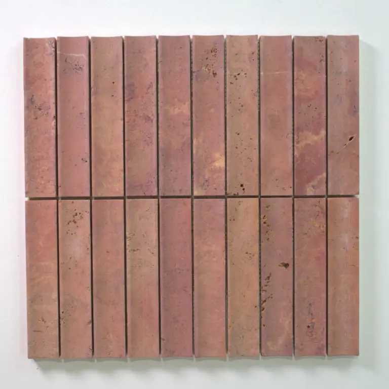 Pinkish-red clay bricks arranged in a tight rectangular grid on a light background (wall panel). 2D pattern emphasizes uniform spacing and texture.