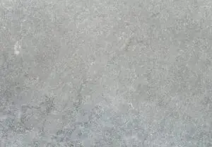 Close-up of a gray concrete surface with subtle texture and tiny cracks, like a sidewalk background.
