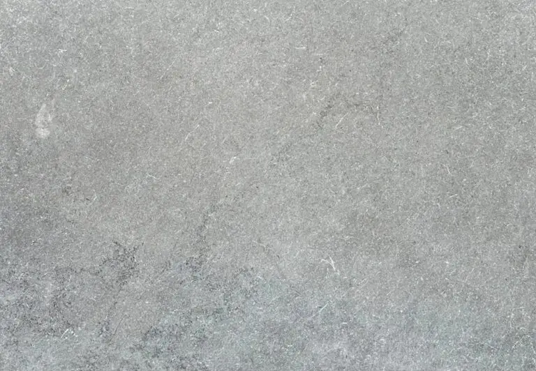 Close-up of a gray concrete surface with subtle texture and tiny cracks, like a sidewalk background.