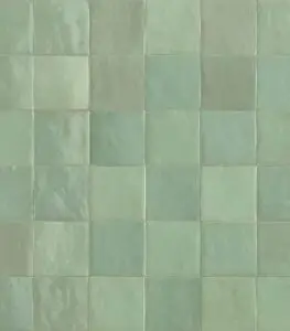 Pastel green square ceramic tiles forming a uniform grid on a wall, with subtle color variations between tiles.