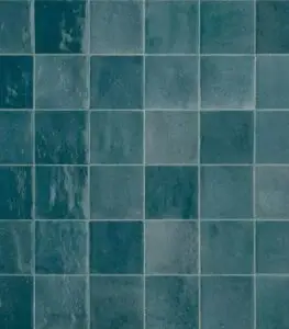 Close-up of a blue-green tiled wall with square ceramic tiles in a grid pattern (horizontal grout lines).