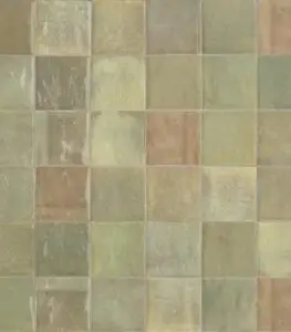 Close-up of a mosaic of square ceramic tiles in earthy greens, yellows, and browns on a wall or floor.