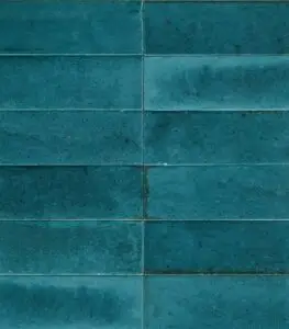 Close-up of a teal tiled wall with rectangular ceramic tiles and light grout lines.