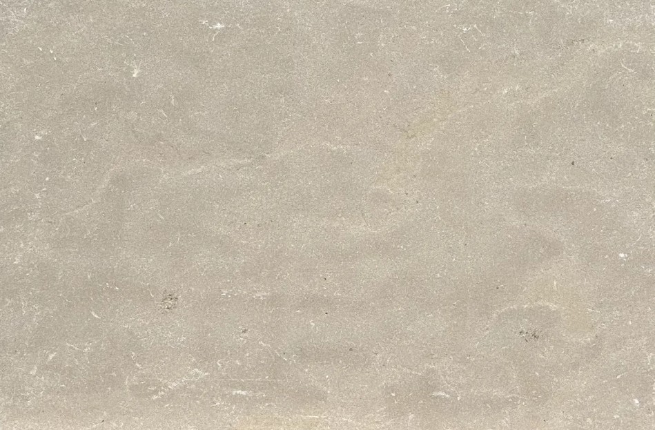 Close-up of a light beige concrete surface with subtle scratches and stains.