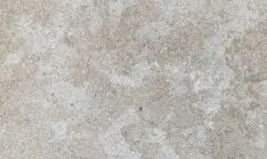 Close-up of a weathered concrete surface with gray, mottled texture and subtle stains.