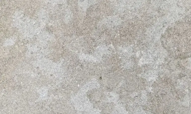 Close-up of a weathered concrete surface with gray, mottled texture and subtle stains.