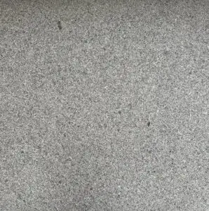 Close-up of a rough gray concrete surface with small aggregates visible.