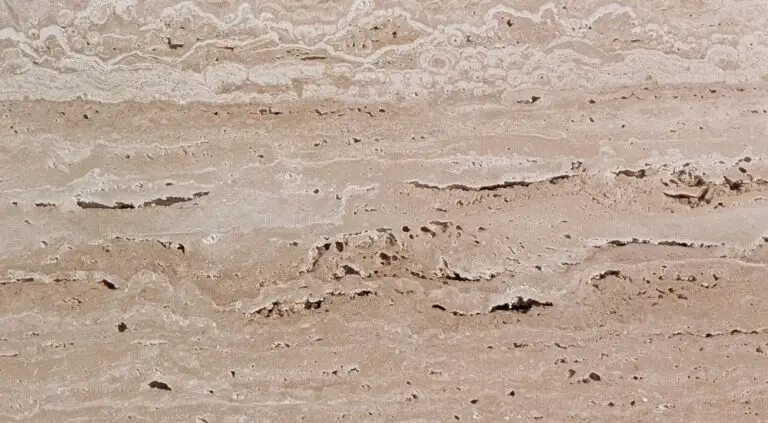 Layered sedimentary rock close-up with beige bands and eroded surface, like a cliff edge.
