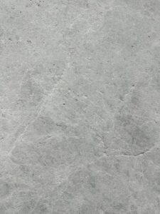 Close-up of a gray concrete surface with subtle scratches and uneven texture.